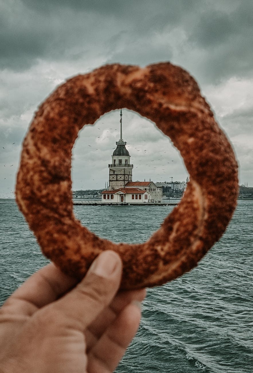 picturesque scenery of historic tower through hole of simit on cloudy sky